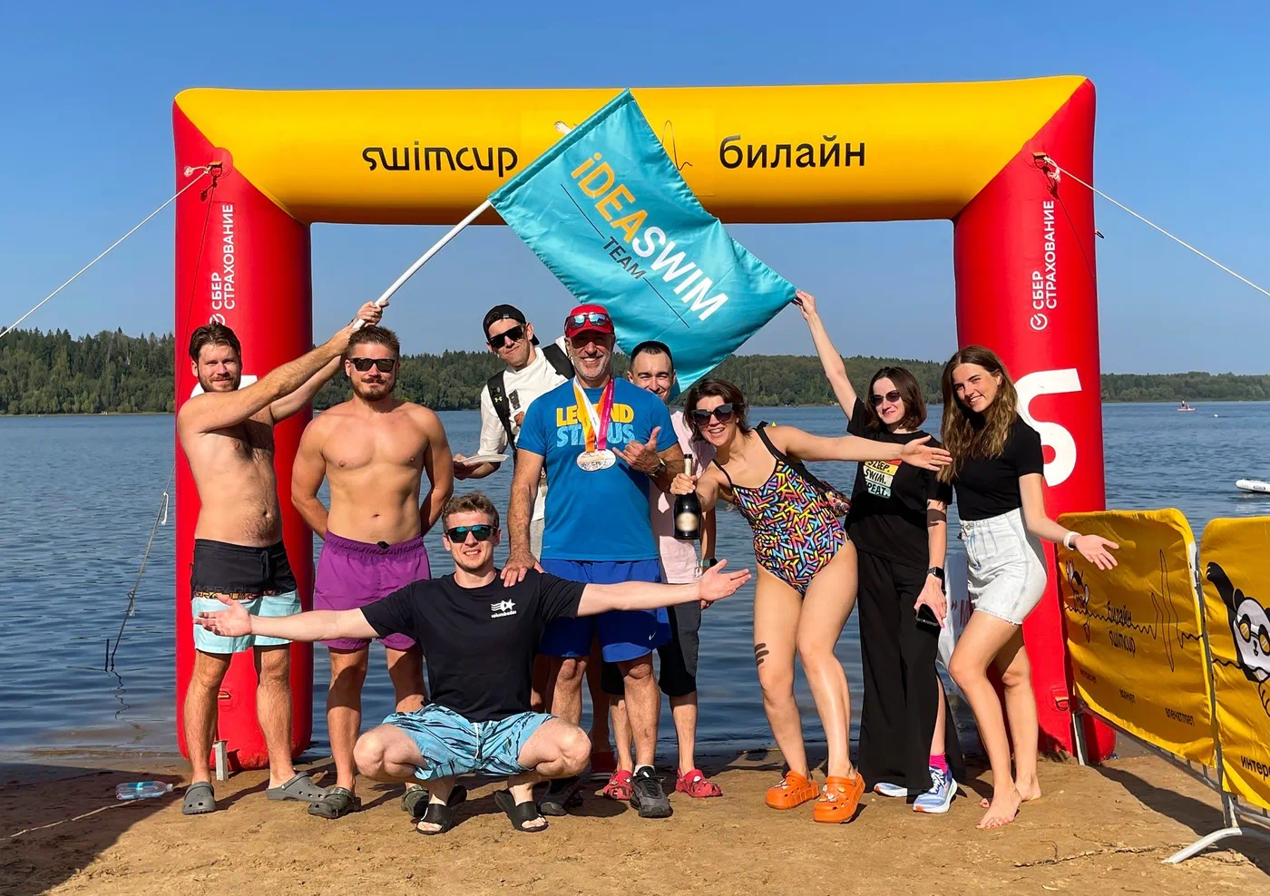 Команда Ideaswim с флагом школы на старте заплыва в открытой воде